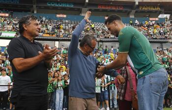 El exfutbolista brasileño Hélio Neto (d), uno de los sobrevivientes del accidente de Chapecoense en 2016, saluda a algunas personas que lo ayudaron el día del accidente, este sábado durante el 'Partido de la amistad eterna' entre Atlético Nacional y Chapecoense en el estadio Atanasio Girardot en Medellín (Colombia).