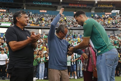 El exfutbolista brasileño Hélio Neto (d), uno de los sobrevivientes del accidente de Chapecoense en 2016, saluda a algunas personas que lo ayudaron el día del accidente, este sábado durante el 'Partido de la amistad eterna' entre Atlético Nacional y Chapecoense en el estadio Atanasio Girardot en Medellín (Colombia).