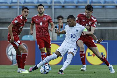 Kylian Mbappé intentar puntear el balón ante la marca de Julián Valarino y la atenta mirada de otros dos jugadores de Gibraltar, durante el partido que Francia ganó ayer 3-0.