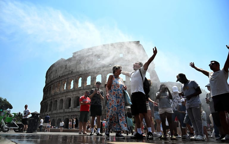 Personal de Protección Civil refresca a turistas con un cañón de agua frente al Coliseo, en Roma, Italia, durante una jornada de intenso calor, el 16 de julio de 2026.