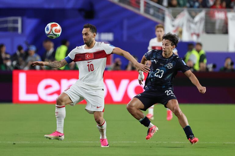 Hakan Calhanoglu (i) de Turquía disputa el balón con Matías Galarza de Paraguay este viernes, en un partido del grupo D del Mundial de la FIFA 2026 entre Turquía y Paraguay, en el estadio Levi´s en Santa Clara (Estados Unidos). 