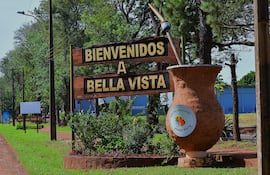 Cartel de madera en Bella Vista que dice 'BIENVENIDOS A BELLA VISTA' con un mate ilustrado.