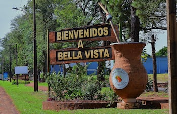 Cartel de madera en Bella Vista que dice 'BIENVENIDOS A BELLA VISTA' con un mate ilustrado.