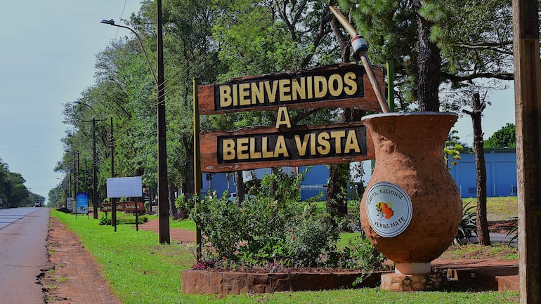 Cartel de madera en Bella Vista que dice 'BIENVENIDOS A BELLA VISTA' con un mate ilustrado.