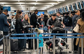 Pasajeros esperan en una fila de registro en el Aeroparque Jorge Newbery, en Ezeiza (provincia de Buenos Aires).