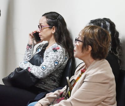 Tres mujeres en sala de espera; una habla por teléfono, otra escucha atentamente y la tercera observa. Ambiente calmado.