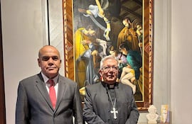 Basilio Nuñez, en traje gris y corbata roja, conversa con el Cardenal Adalberto Martinez, vestido de negro con cruz, en el Arzobispado de Asunción.