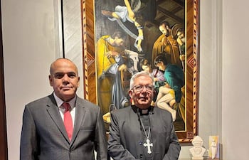 Basilio Nuñez, en traje gris y corbata roja, conversa con el Cardenal Adalberto Martinez, vestido de negro con cruz, en el Arzobispado de Asunción.