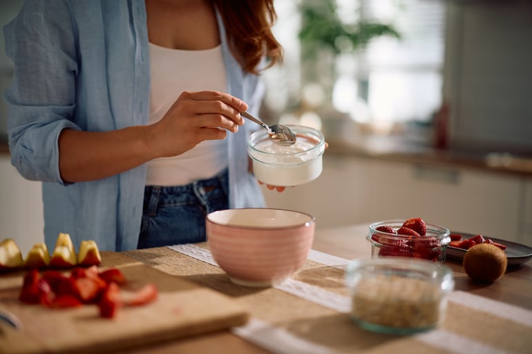 Mujer se sirve yogur griego.