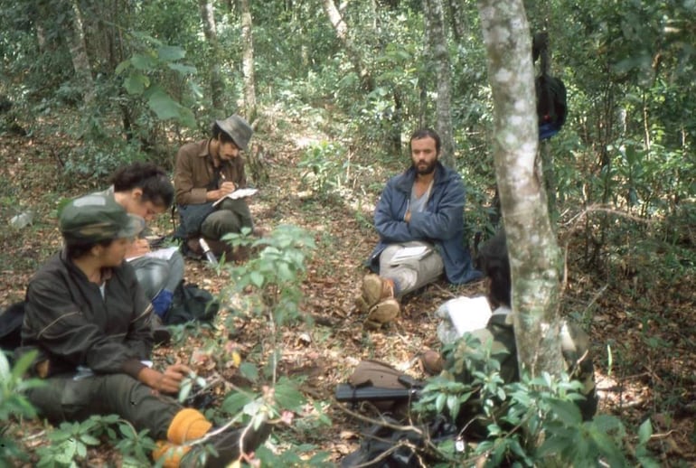 Foto inédita del grupo Cutumay Camones, en algún lugar de Morazán. Tomada durante los años 80 en la zona de combate. En primer plano, Teresita Guardado, escribiendo (Foto del archivo personal del poeta Carlos Ernesto García).