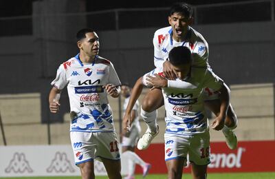 Leandro Meza se sube a la espalda de Sebastián Quintana, autor del gol de Nacional para la victoria sobre Tacuary. Gustavo Caballero se suma a la celebración