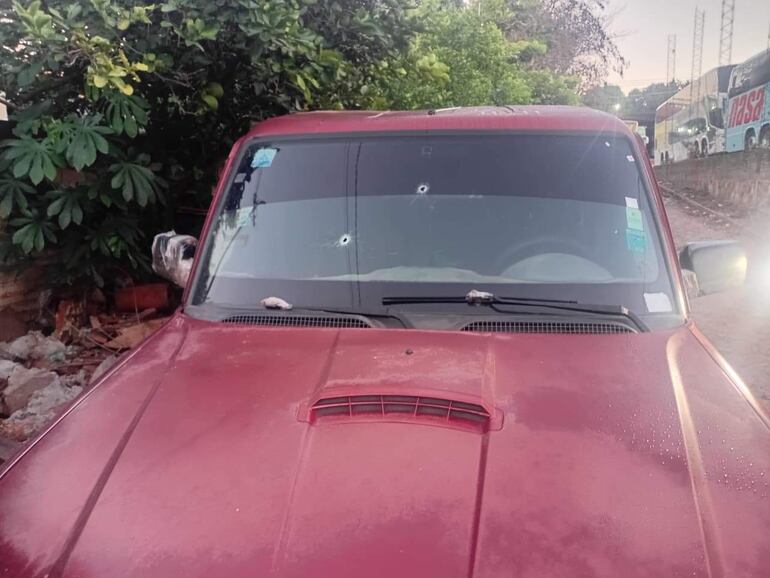 Vehículo rojo con agujeros de bala en el parabrisas. Los impactos de bala se diron tras el tiroteo con persecución que derivó de un intento de asalto en Fernando de la Mora, zona sur.