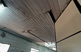 Interior de la sede de la Fiscalía con paredes sencillas y ventilador, sin personas presentes.