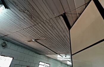 Interior de la sede de la Fiscalía con paredes sencillas y ventilador, sin personas presentes.