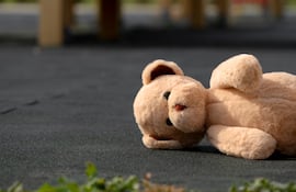 Imagen de un osito de peluche abandonado en la calle, en alusión a la tristeza de la familia cuando hay un niño desaparecido.