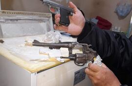 Un guardiacárcel exhibe las dos armas que fueron encontradas en una de las celdas del pabellón que alberga a los miembos del PCC.