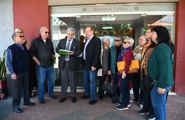 Miembros de la Unión Nacional de Asegurados de Paraguay frente a la Fiscalía General del Estado, donde presentaron una nota y las firmas recolectadas para urgir la investigación fiscal de Vicente Bataglia y sus consejeros del IPS.