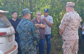 El papá del secuestrado, Valmir De Brum, y el cuñado de la víctima, Silvio Giménez, hablan con el director de Policía de Caaguazú, comisario general Jorge Aquino (de caqui), y con el comandante del CODI, general de brigada Alberto Gaona (de verde). Atrás, aparece el subjefe de Antisecuestro, subcomisario Marcial Castillo (de negro).