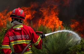 Un bombero de Portugal combate un incendio forestal.