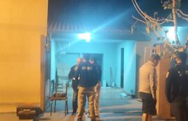 Agentes policiales verifican la casa en donde ocurrió el asalto.