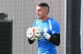 Arquero de la Albirroja con camiseta azul y pantalones negros, sosteniendo un balón, en campo de entrenamiento.
