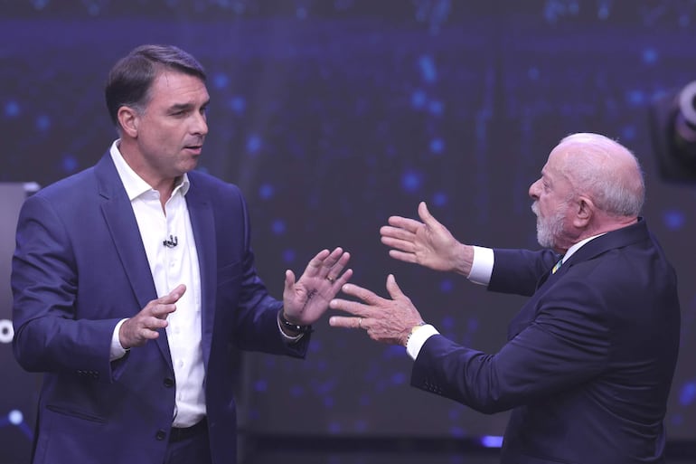 AME7375. SAO PAULO (BRASIL), 18/10/2026.- El presidente de Brasil y candidato a la reelección, Luiz Inácio Lula da Silva (d), y el opositor Flávio Bolsonaro, discuten durante el primer debate presidencial este domingo, en la sede de Rede Bandeirantes en Sao Paulo (Brasil). Lula y Bolsonaro protagonizaron un tenso cruce de acusaciones de corrupción en el primer cara a cara entre ambos por televisión con miras a la segunda vuelta de las elecciones presidenciales del próximo domingo. EFE/ Sebastiao Moreira
