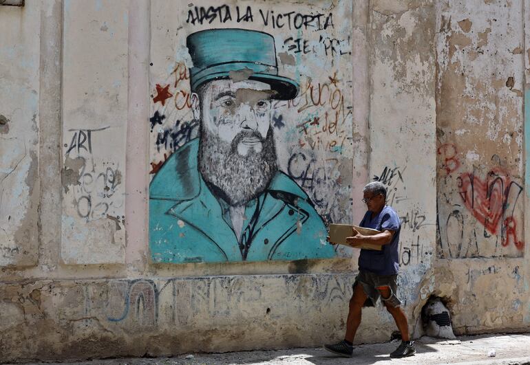 Una persona camina junto a un grafiti del líder de la revolución cubana Fidel Castro, en La Habana (Cuba)