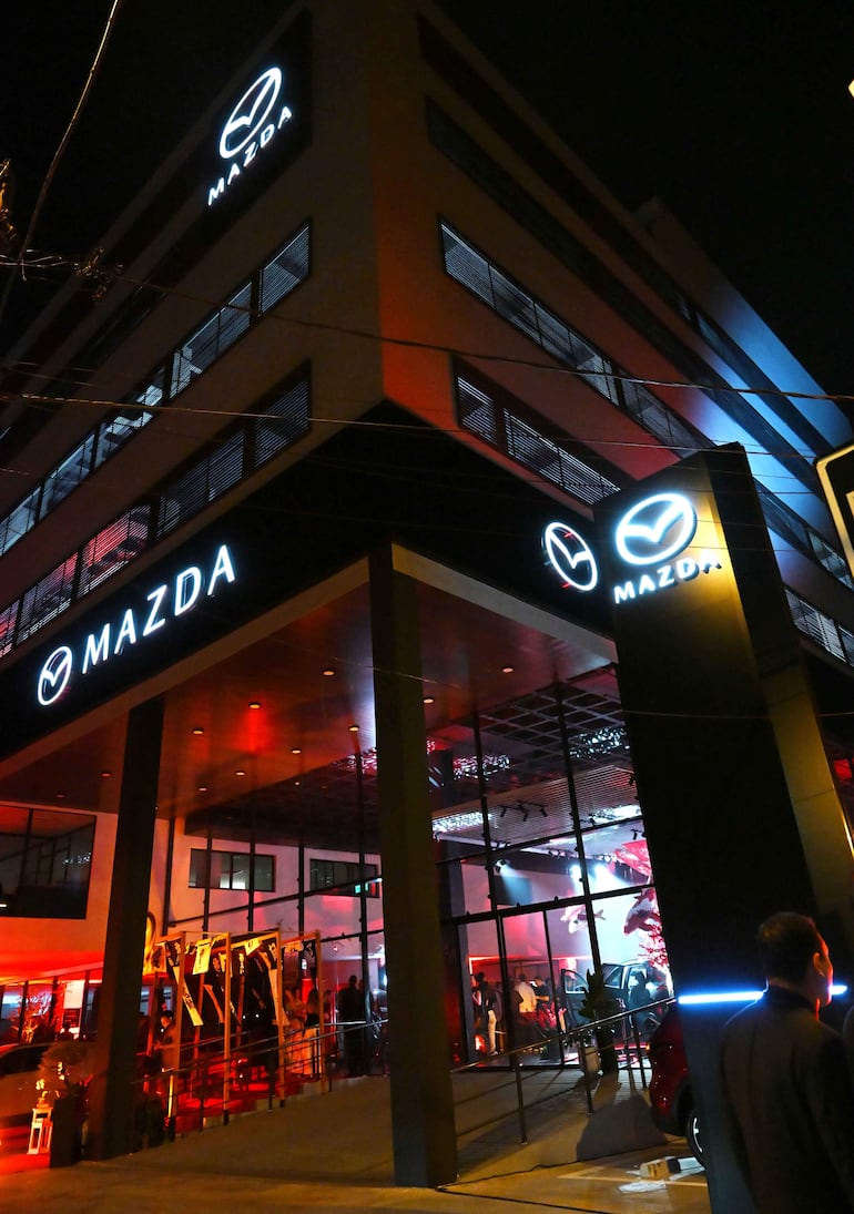 Fachada del nuevo Show Room Mazda iluminada con luces rojas, mostrando el logotipo de la marca en un entorno urbano.
