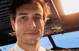 Bertazzo, hombre con cabello castaño, camisa blanca y corbata, sonríe en la cabina con paneles de control de avión.