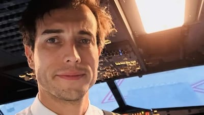 Bertazzo, hombre con cabello castaño, camisa blanca y corbata, sonríe en la cabina con paneles de control de avión.