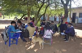 Estudiantes soportaban el intenso frío de ayer en la clase de Ciencias Naturales a la intemperie, bajo árboles sin aulas en la escuela Nueva Asunción de Chaco´i.