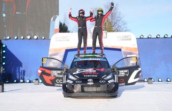 Elfyn Evans y Scott Martin celebran el triunfo en el rally blanco arriba del techo del rendidor Toyota GR Yaris Rally1.