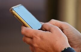 Personas revisando sus teléfonos celulares.