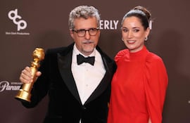 El cineasta brasileño Kleber Mendonca Filho y la productora francesa Emilie Lesclaux posan con el Globo de Oro a la Mejor Película en lengua extranjera por "El agente secreto".