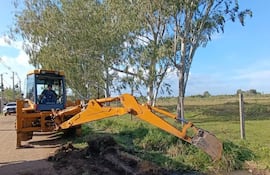 Tarea de limpieza de un canal de desagüe pluvial con apoyo de una retroexcavadora en la zona urbana de Pilar.