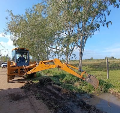Tarea de limpieza de un canal de desagüe pluvial con apoyo de una retroexcavadora en la zona urbana de Pilar.