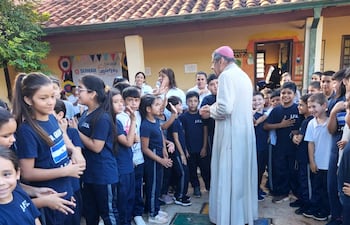 Monseñor Ricardo Valenzuela juega a la rayuela con los niños.