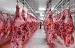 Medias reses colgadas en un frigorífico.