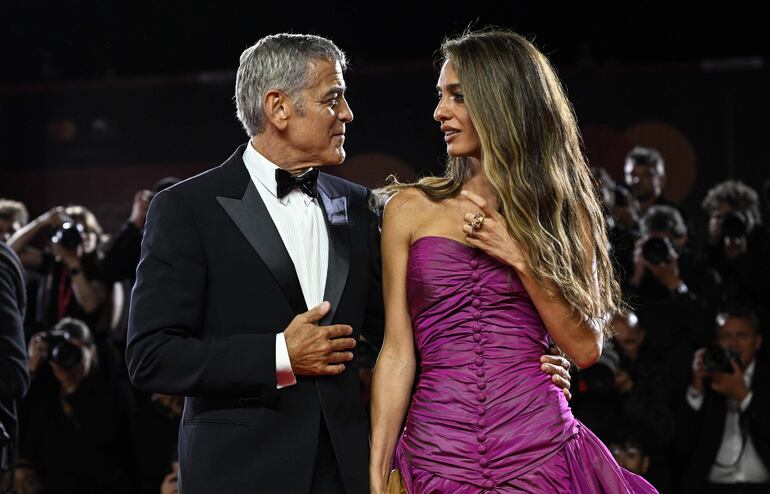 ¡Miradas cómplices! George Clooney y su esposa Amal Alamuddin en la premier de 'Jay Kelly'. (EFE/EPA/RICCARDO ANTIMIANI)
