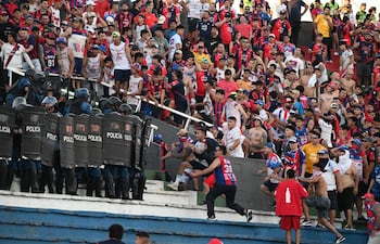 Los agentes policiales se agrupan para enfrentar a los integrantes de la barra brava de Cerro Porteño, en el enfrentamiento en Graderías Norte del Defensores del Chaco.