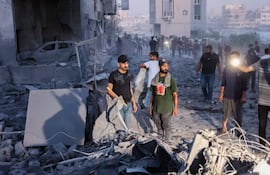 Palestinos buscan sus pertenencias entre los escombros tras la ofensiva israelí contra la milicia de Hamás en Gaza.