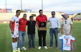 El histórico delantero Óscar "Tacuara" Cardozo recibe el reconocimiento en el estadio Arsenio Erico, liderado por el presidente de Nacional, Enrique Sánchez.