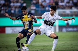 El joven volante ofensivo de Olimpia, Eduardo Delmás intenta proteger el esfpérico ante la presencia del extremo del Sportivo Trinidense, Pedro Zarza. (Foto: @elClubOlimpia)