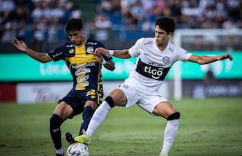 El joven volante ofensivo de Olimpia, Eduardo Delmás intenta proteger el esfpérico ante la presencia del extremo del Sportivo Trinidense, Pedro Zarza. (Foto: @elClubOlimpia)