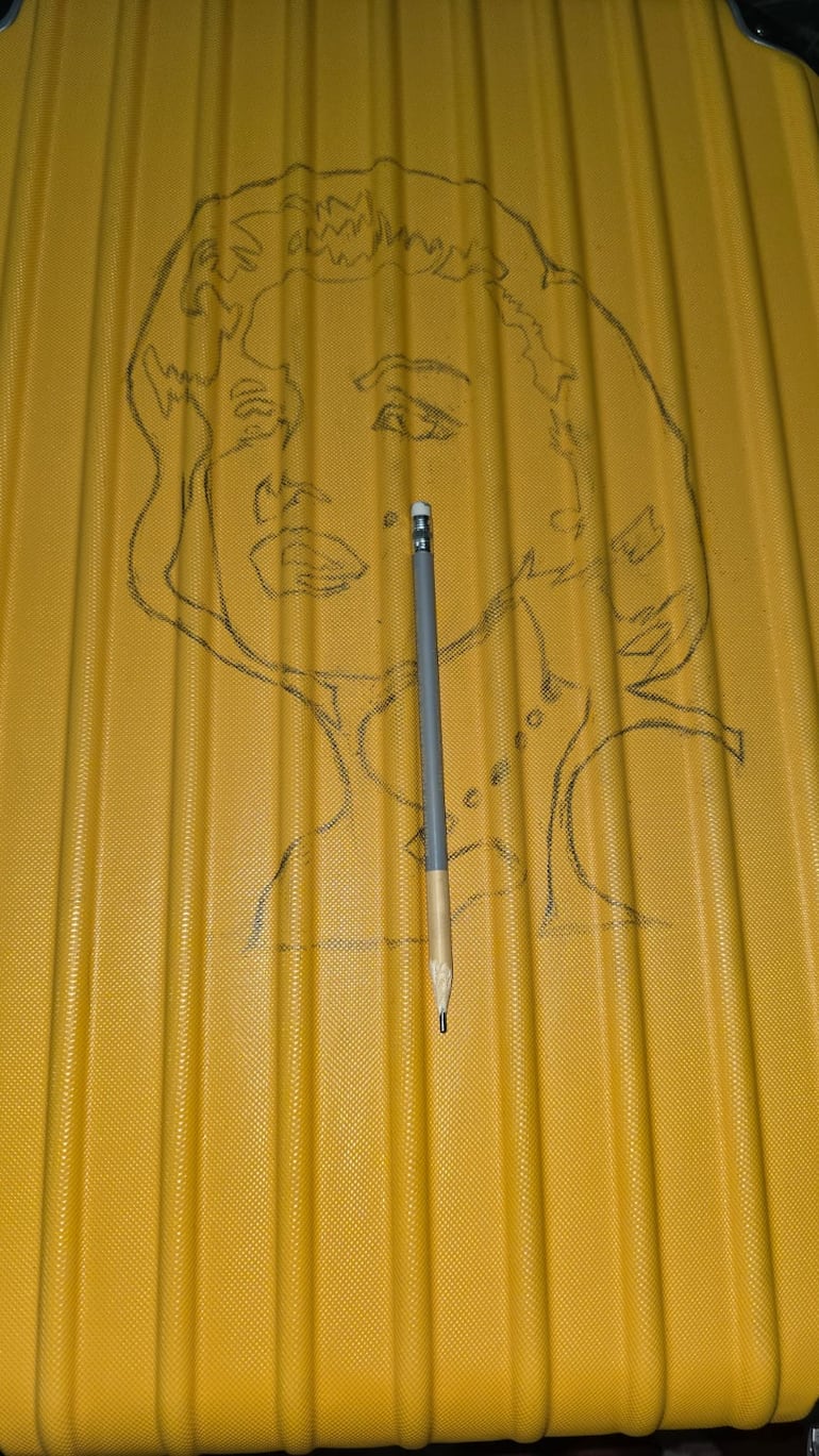 Así comenzó Carlos Troche a dibujar sobre la maleta amarilla que regaló a su esposa Shelby Katyana González. (Gentileza)