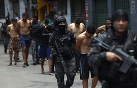 Integrantes de la Policía de Río de Janeiro trasladan a un grupo de personas durante un operativo este martes, en Río de Janeiro (Brasil).
