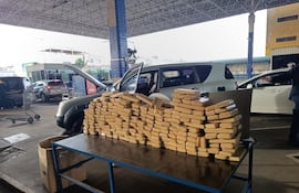 La droga incautada y en el fondo la camioneta utilizada para el transporte.