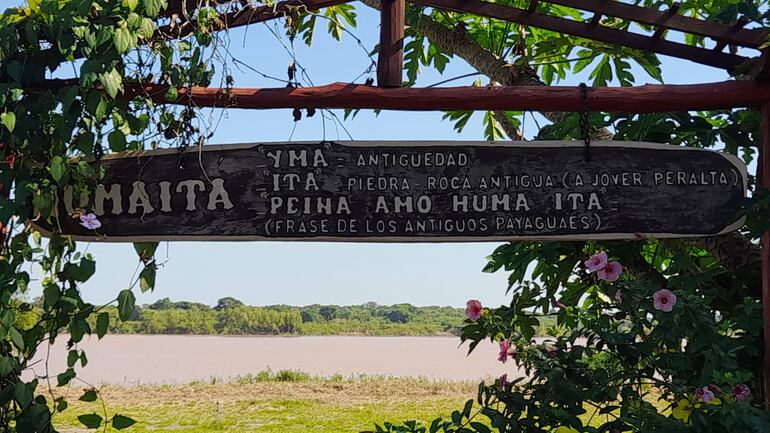 El significado de Humaitá, escrito en una madera ubicada frente al museo histórico, al fondo se ve las aguas del río Paraguay.
