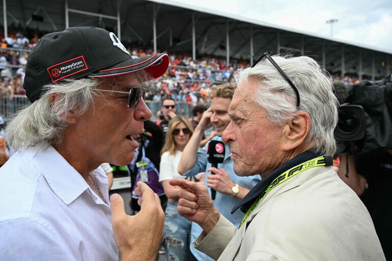 El músico Jon Bon Jovi habla con el actor Michael Douglas en el marco del Gran Premio de Fórmula Uno de Miami 2025 en el Autódromo Internacional de Miami. (CHANDAN KHANNA / AFP)