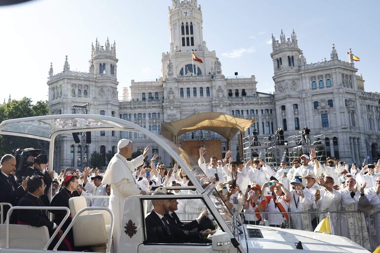 El papa León XIV saluda desde el papa móvil a su llegada a la plaza Cibeles para oficiar la misa del Corpus Christi, este domingo, en Madrid.
